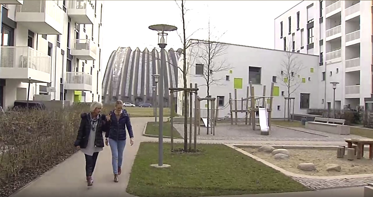 Im Innenhof von Wohnprojekt 5 mit blick auf Kinderspielplatz, im Hintergrund die Paketposthalle